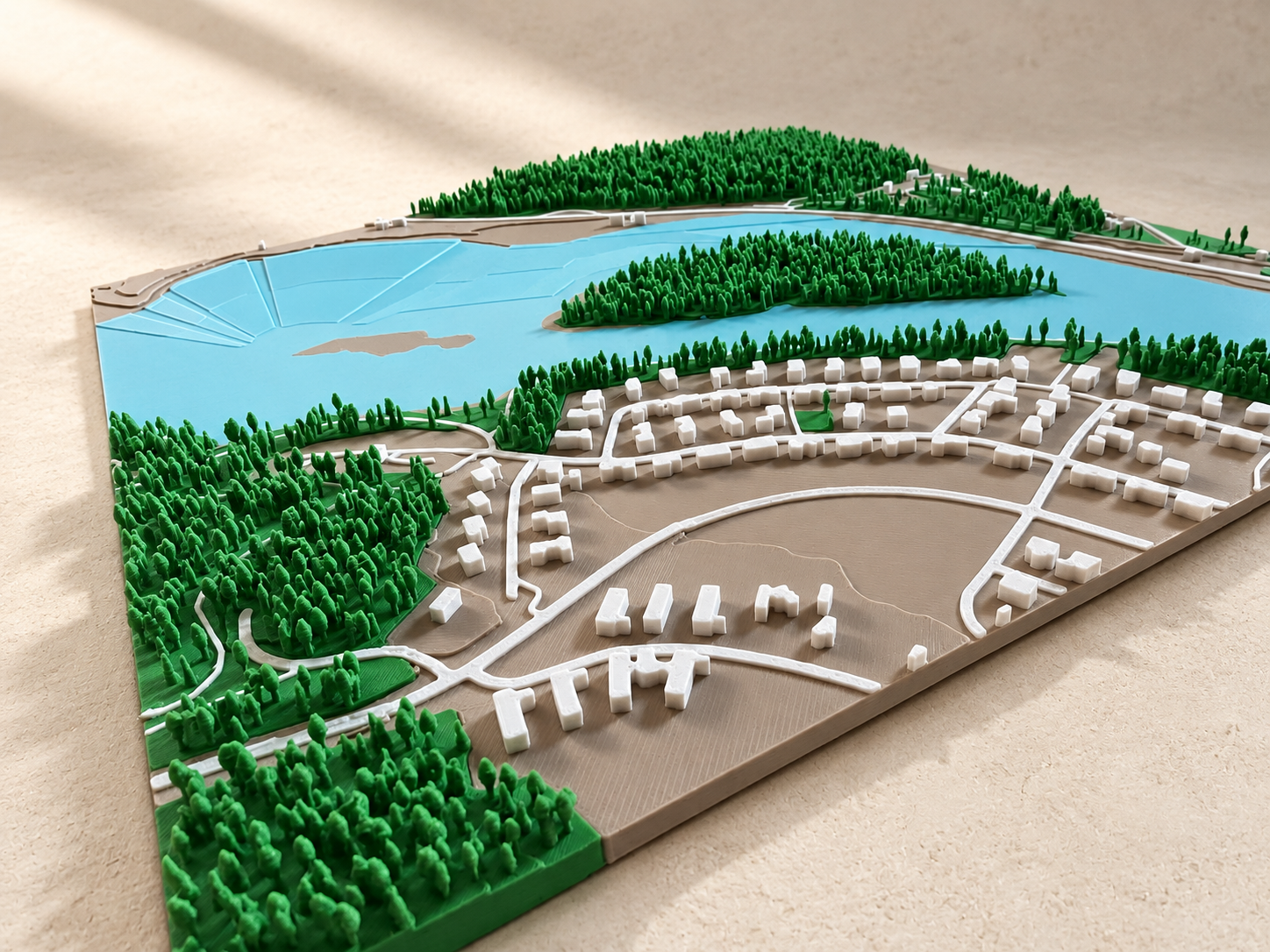 Close-up of a 3D map with raised trees, buildings and blue water